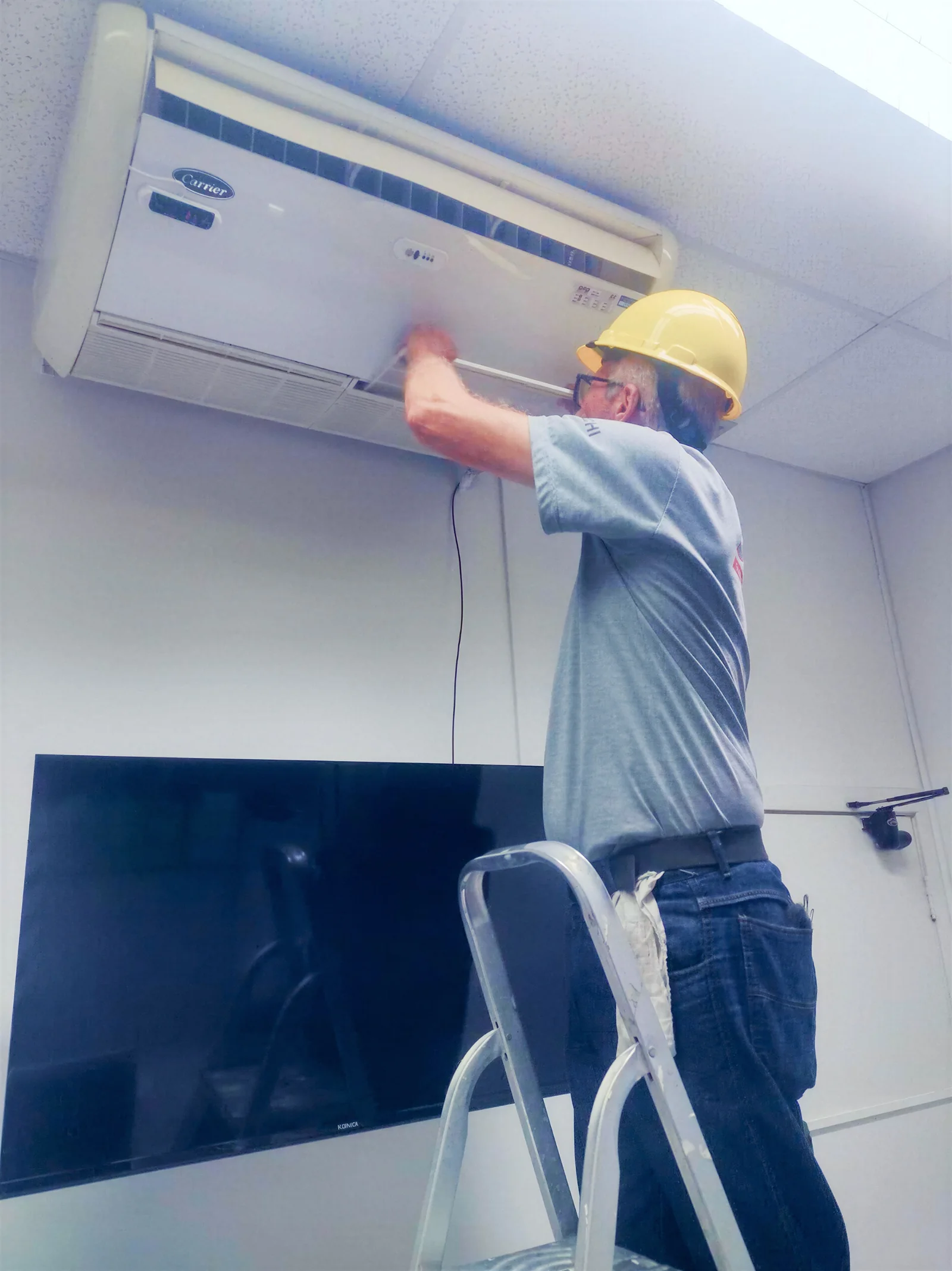 Técnico da Speedy trabalhando em aparelho de climatização comercial